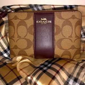 COACH corner zip wristlet in signature canvas.